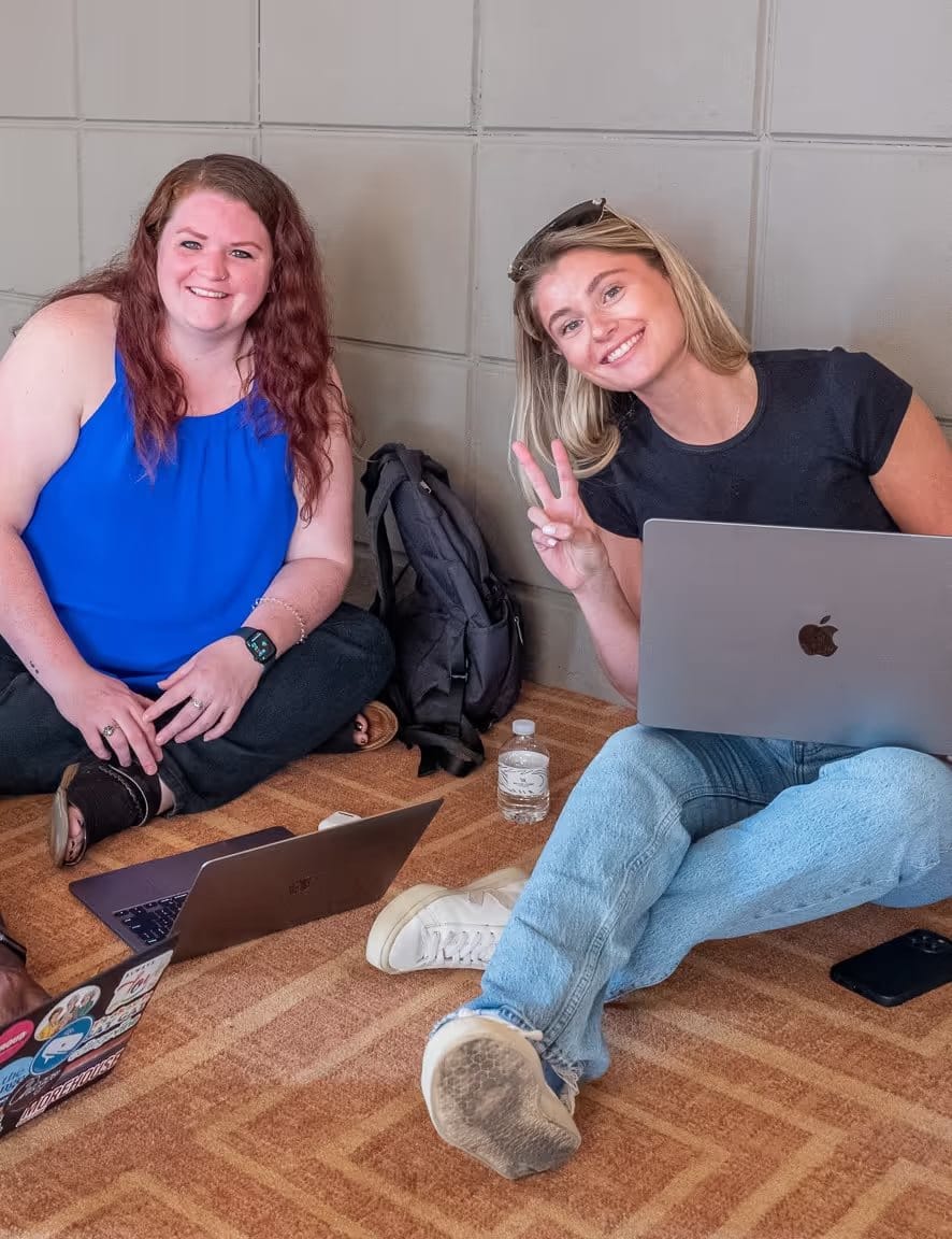 Two teammates collaborating with laptops