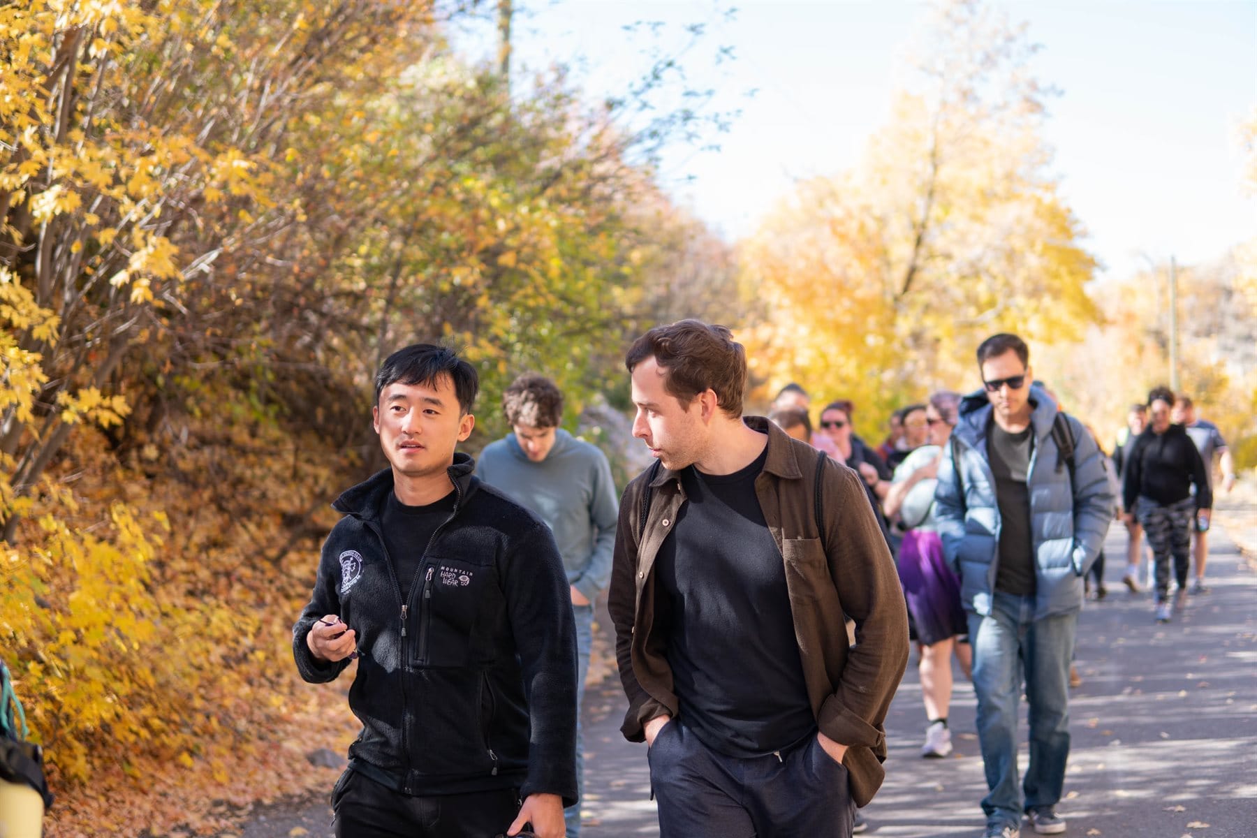 A group walking through autumn trees